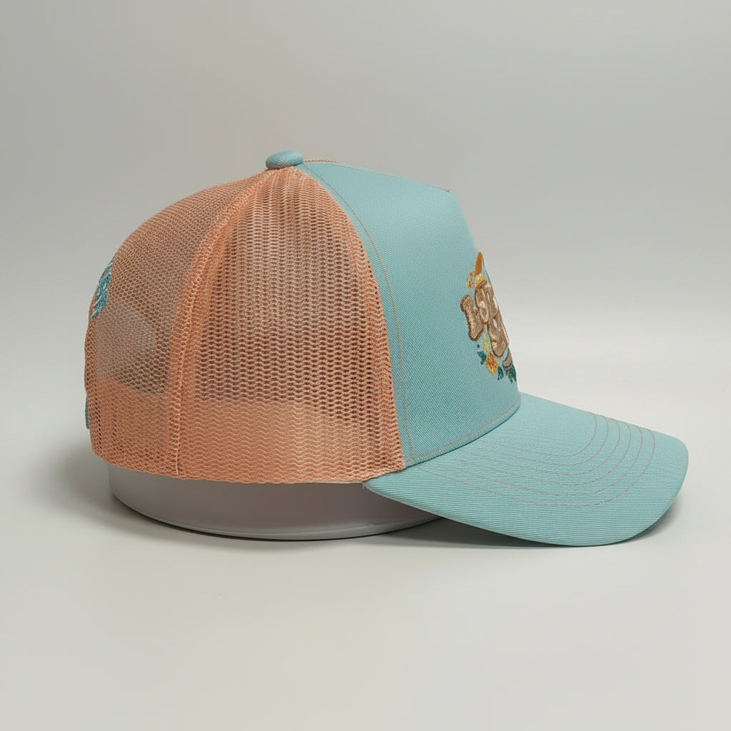 Side view of the L8R SK8R Trucker Hat. Pale Blue and Orange. 